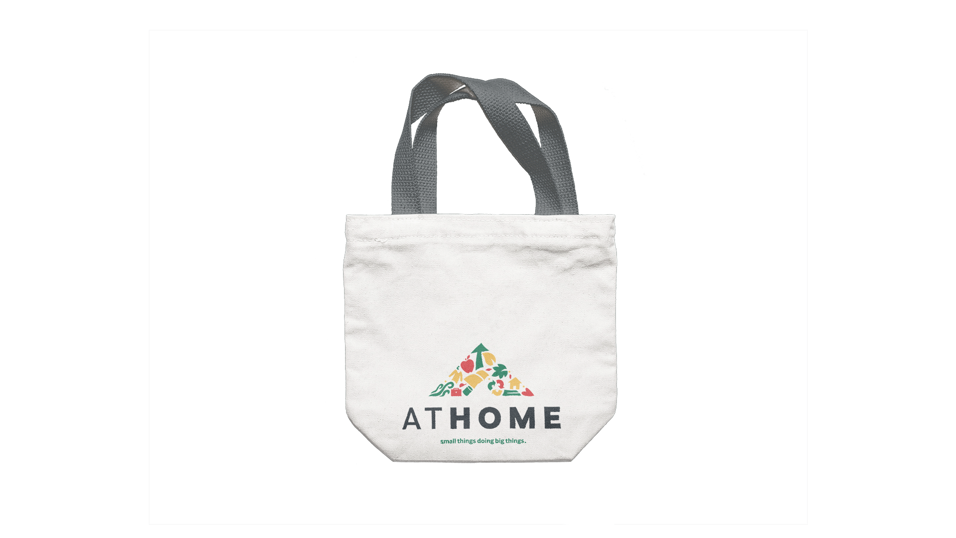 White tote bag with grey straps and the full-colour At Home logo printed near the bottom, centred.