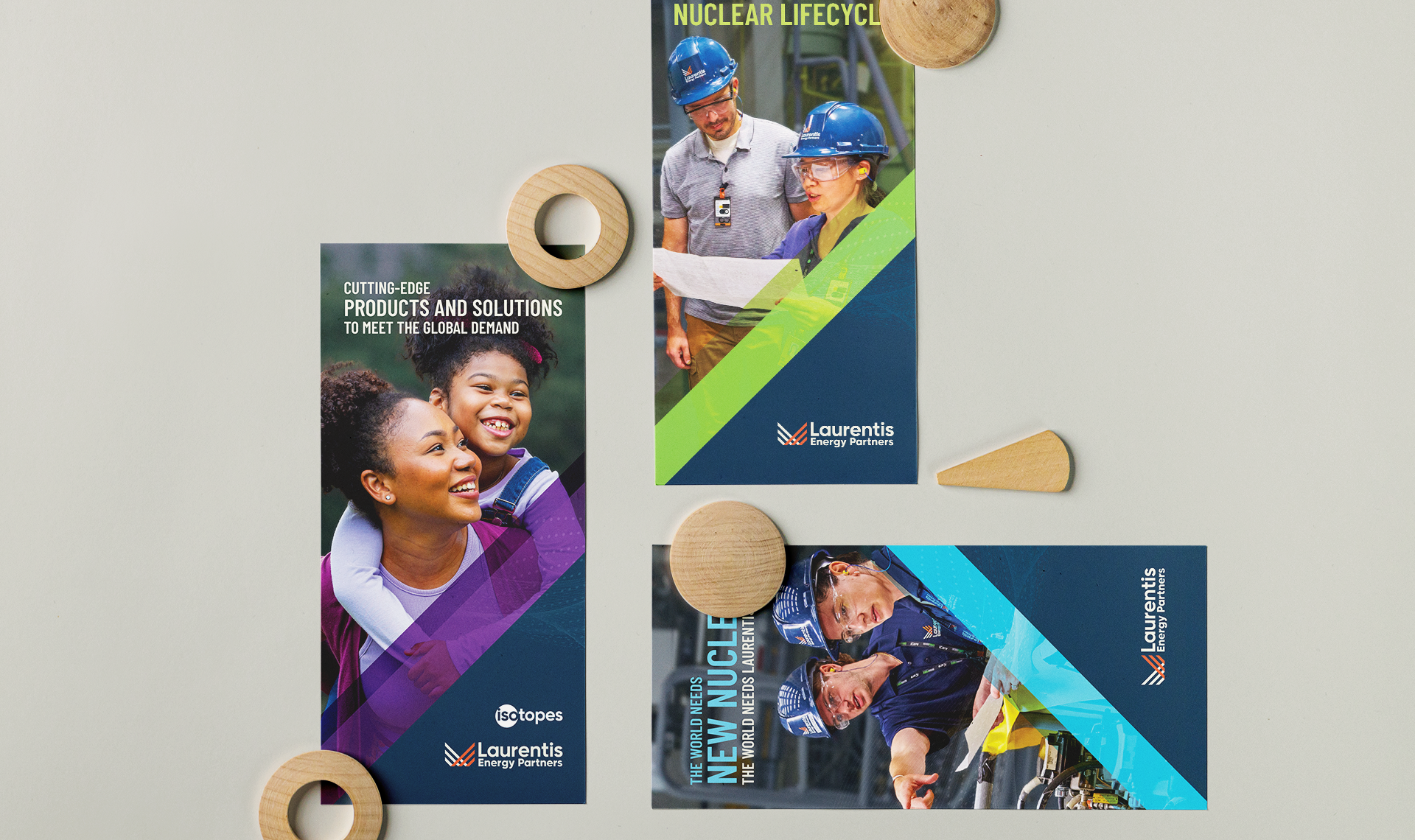 Three brochures arranged together with wooden shapes scattered on a grey background.