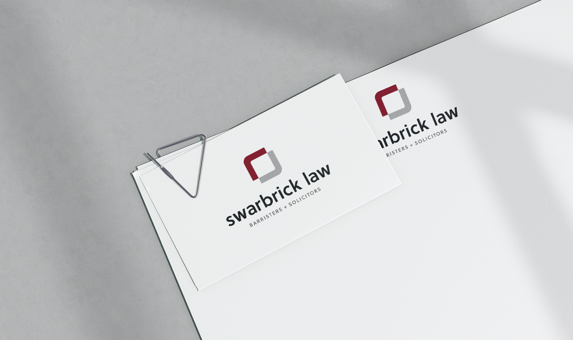 Swarbrick Law business card paper clipped to matching letterhead.